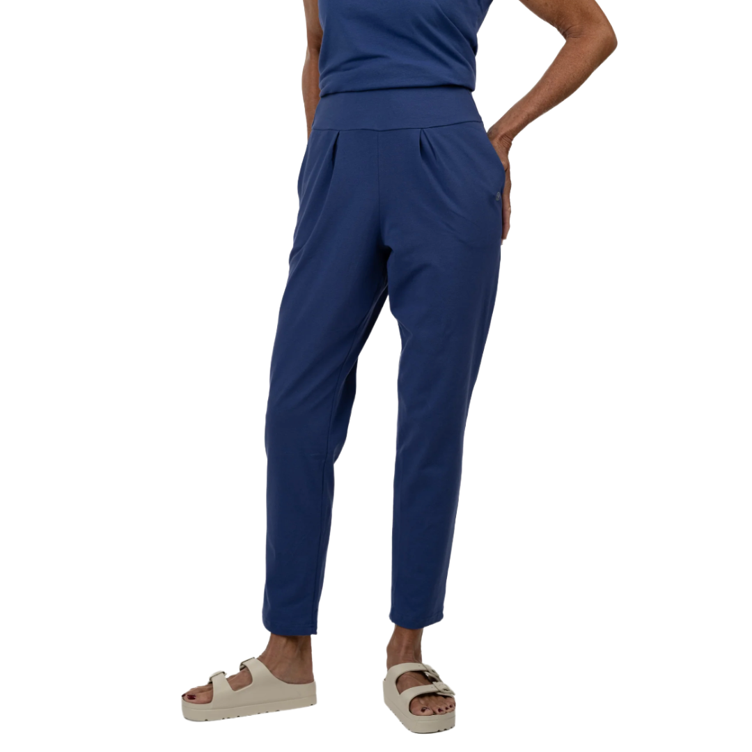 Blue ankle-length pants with a wide waistband, paired with a matching top and beige sandals.