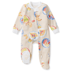 A baby onesie with a colorful breakfast-themed print featuring croissants, pancakes, fruits, and cereal. The onesie has a zipper closure and ribbed cuffs.