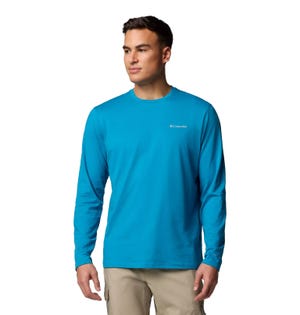 A man wearing a bright blue Columbia long-sleeve shirt and beige cargo pants.