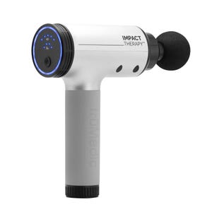 A handheld massage gun with a black massage head, digital interface on the rear, and \“truMedic\“ and \“IMPACT Therapy\“ branding.