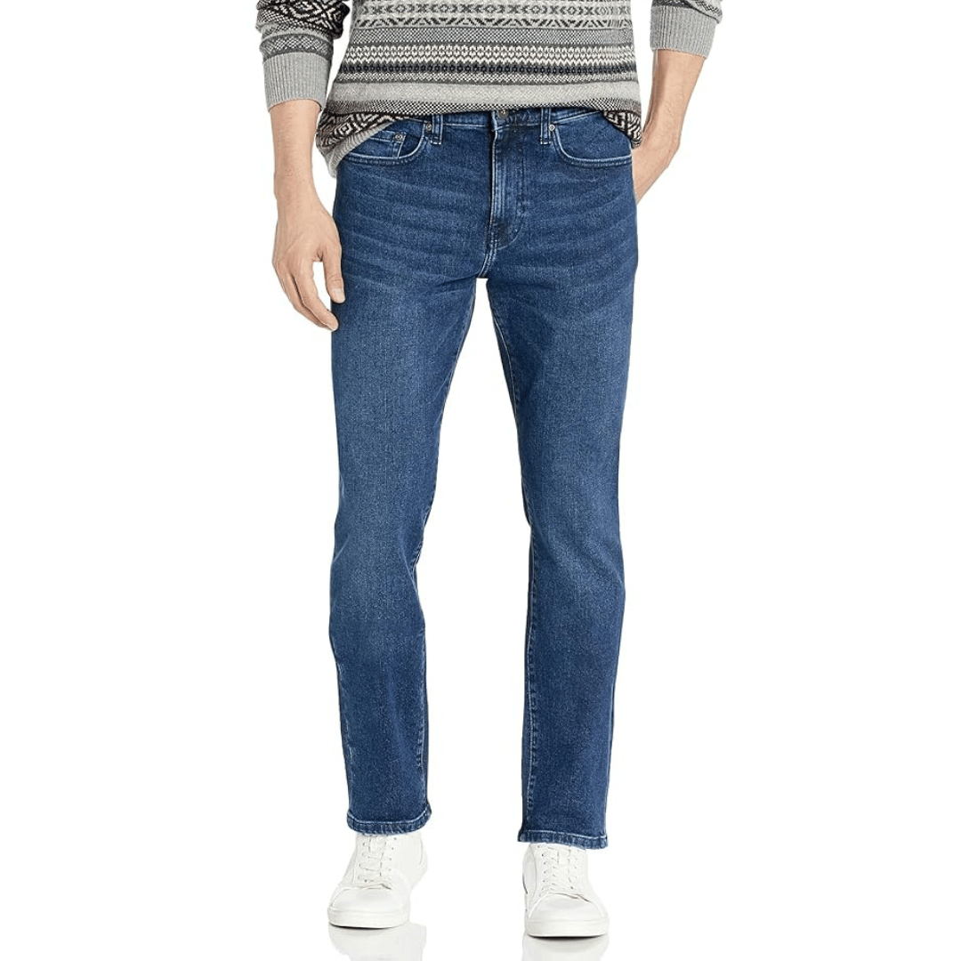 A person wearing straight-leg blue jeans, a patterned sweater, and white sneakers.