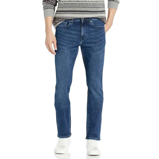 A person wearing straight-leg blue jeans, a patterned sweater, and white sneakers.