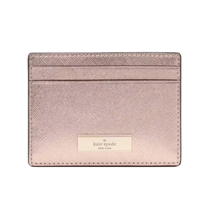 The Kate Spade Kenzie Metallic Card Holder is a sleek, shimmering pink accessory with two card slots and a gold logo plaque on the front.