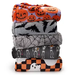 A stack of five plush throw blankets with Halloween-themed patterns, including pumpkins, bats, spider webs, skeletons, and ghosts, in a color scheme of orange, grey, white, and black.