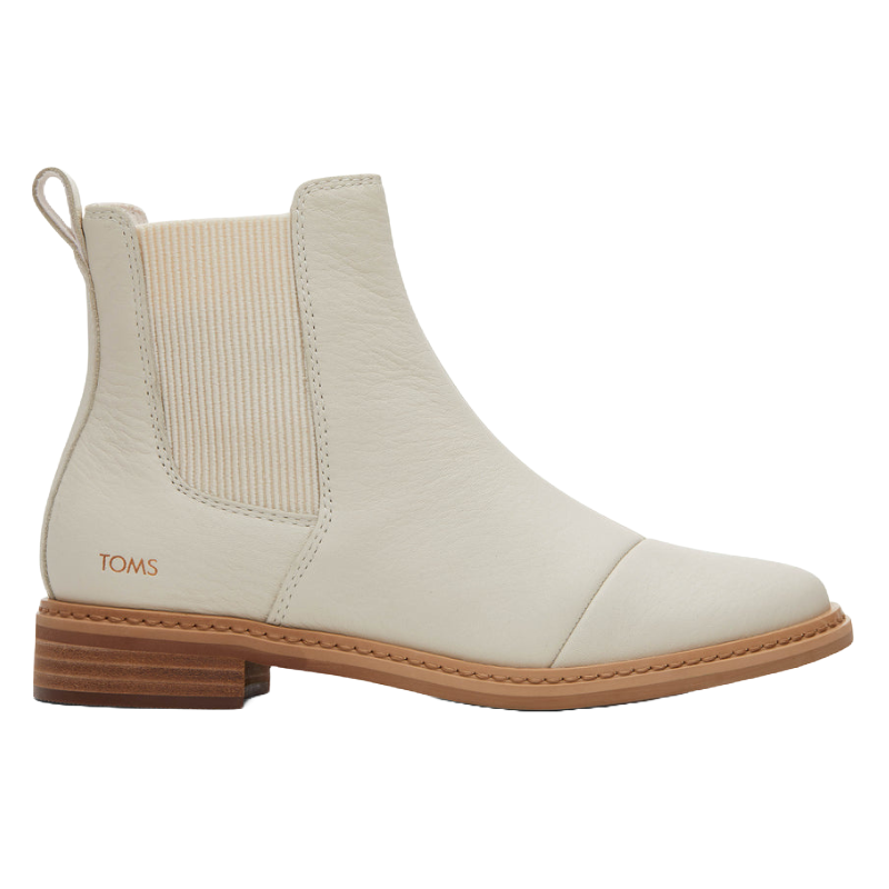 Cream-colored leather Chelsea boot with elastic side panels, pull tab, and brown sole; branded with \“TOMS\“ on the heel.