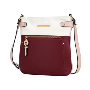 A two-tone crossbody bag featuring a burgundy pocket with a gold zip and a white upper section. Accented with a pink strap and gold hardware, including a charm with an \“M\“ emblem.