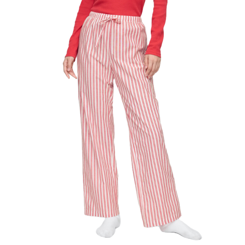 Red and white striped poplin pajama pants with a drawstring waist, worn by a person dressed in a long-sleeved red top, completing a cozy loungewear look.