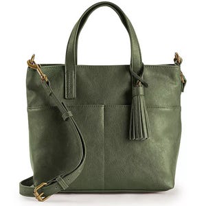 A green leather tote bag with dual handles, a detachable crossbody strap, and a tassel accent.