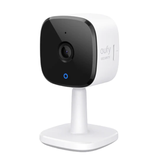A Eufy security camera with a compact design, featuring a black front panel, lens, and a white stand for indoor use.