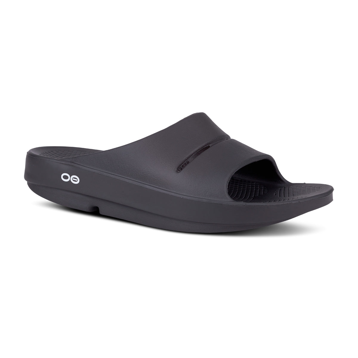 Black slide sandal with a single wide strap and textured footbed, featuring a small circular logo on the side.