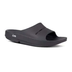 Black slide sandal with a single wide strap and textured footbed, featuring a small circular logo on the side.