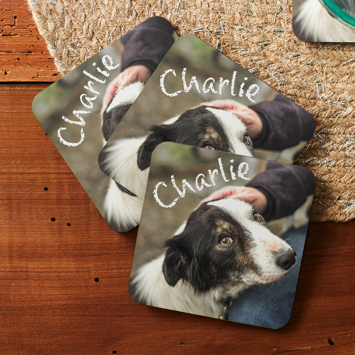 Square photo coasters featuring a dog named Charlie, with a high-quality image of the dog being petted. Coasters have a rustic design on a wooden surface with a textured background, offering a personal touch.