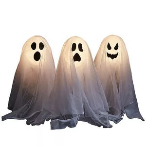 Three ghost decorations with light-up bodies and different facial expressions, covered with white sheets and featuring black cut-out eyes and mouths.