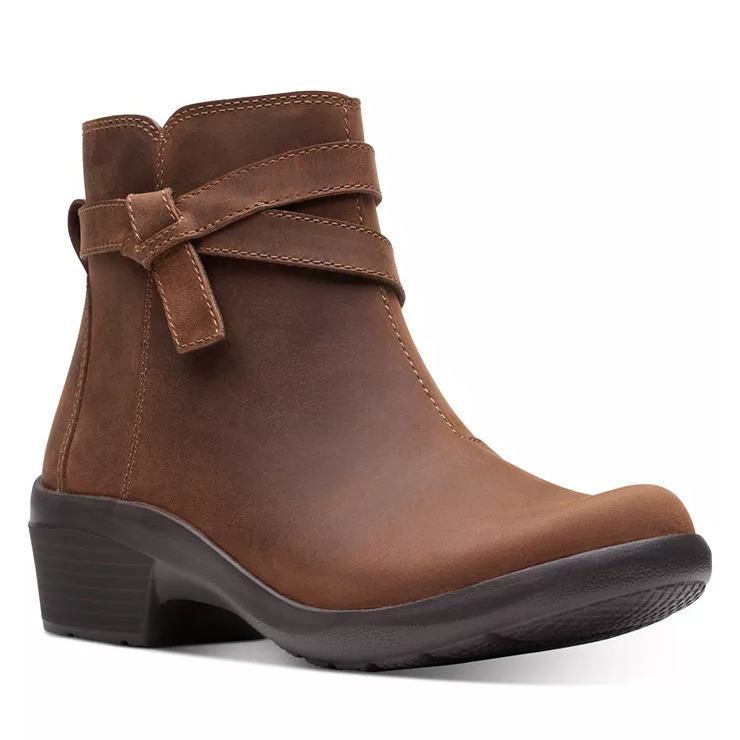 Brown ankle boot with a low block heel, featuring decorative strap detailing and smooth leather finish.