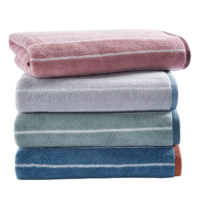 A stack of four towels in different colors: pink, gray, green, and blue, each with thin horizontal stripes near the edges.