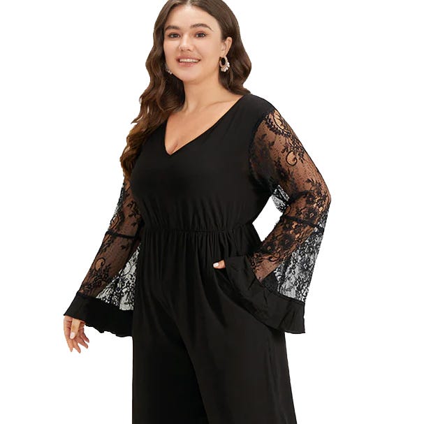 A woman wears a black long-sleeve jumpsuit featuring lace sleeves and a V-neckline.
