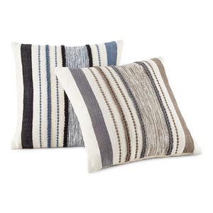 Two square pillows feature a textured, nubby fabric with horizontal stripes in calming blues and browns, one with a light center panel and the other with dark edges.