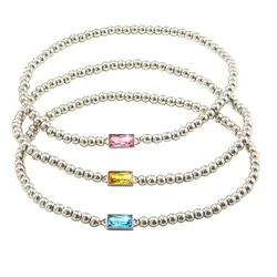 Three silver beaded bracelets feature rectangular gemstones in pink, yellow, and blue.