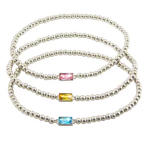 Three silver beaded bracelets feature rectangular gemstones in pink, yellow, and blue.