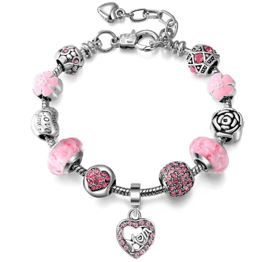A charm bracelet with pink and silver beads featuring floral designs, a rose motif, and a heart-shaped charm encrusted with pink crystals.