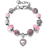 A charm bracelet with pink and silver beads featuring floral designs, a rose motif, and a heart-shaped charm encrusted with pink crystals.