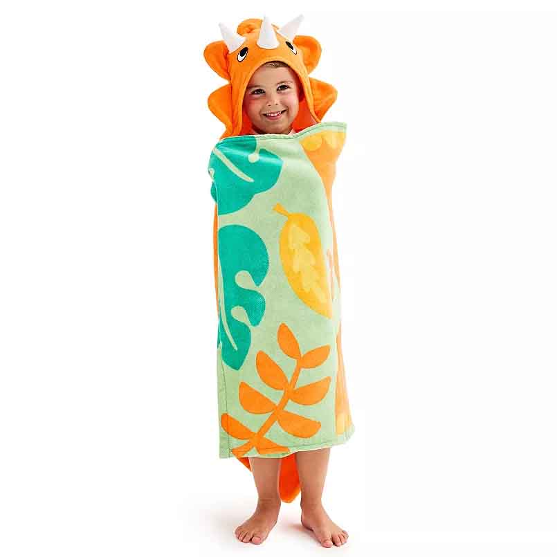 Child wearing an orange dinosaur-themed hooded towel with white horns and a leaf pattern in green, yellow, and orange tones.