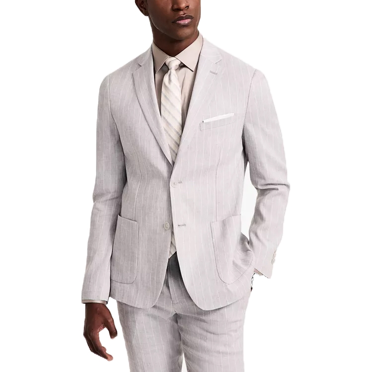 A man wears a light gray pinstripe suit with a beige shirt and striped tie. The suit features a notch lapel and patch pockets.