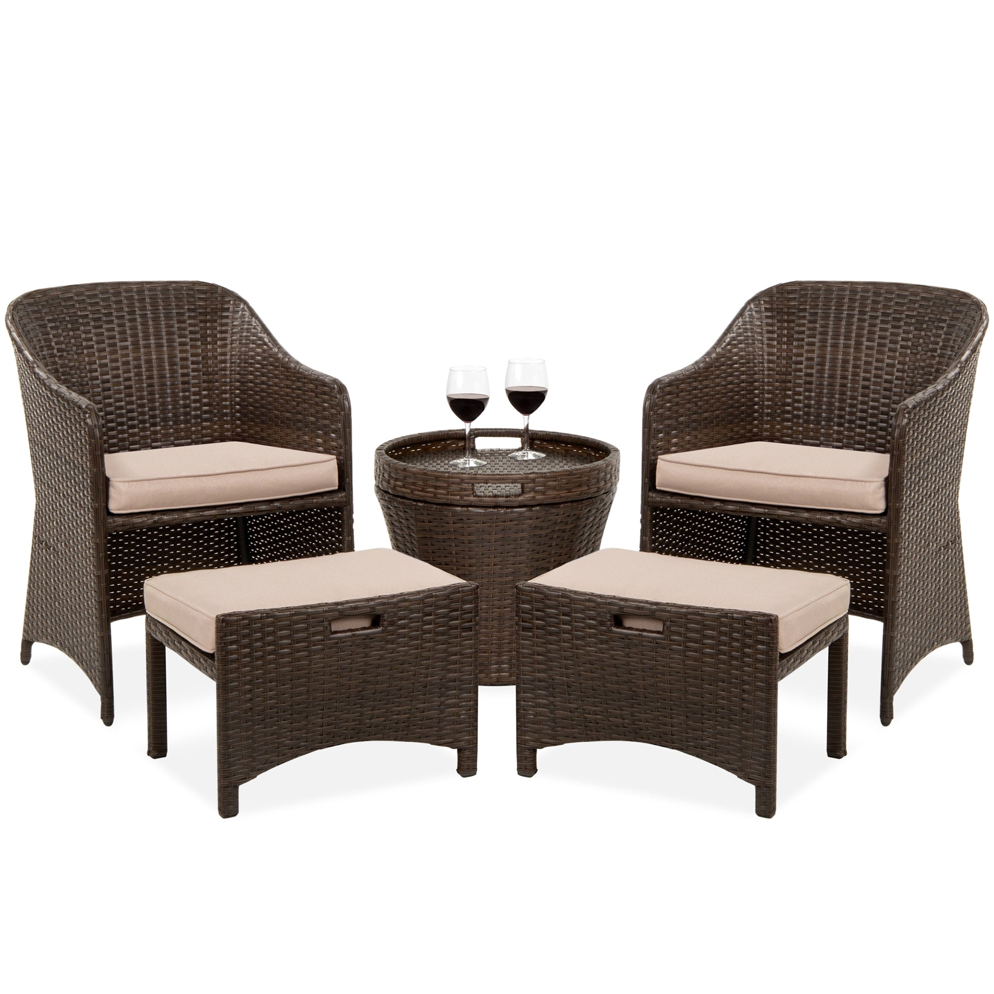 A five-piece patio set consisting of two wicker armchairs with beige cushions, two matching ottomans, and a round wicker table with a glass top and two wine glasses.