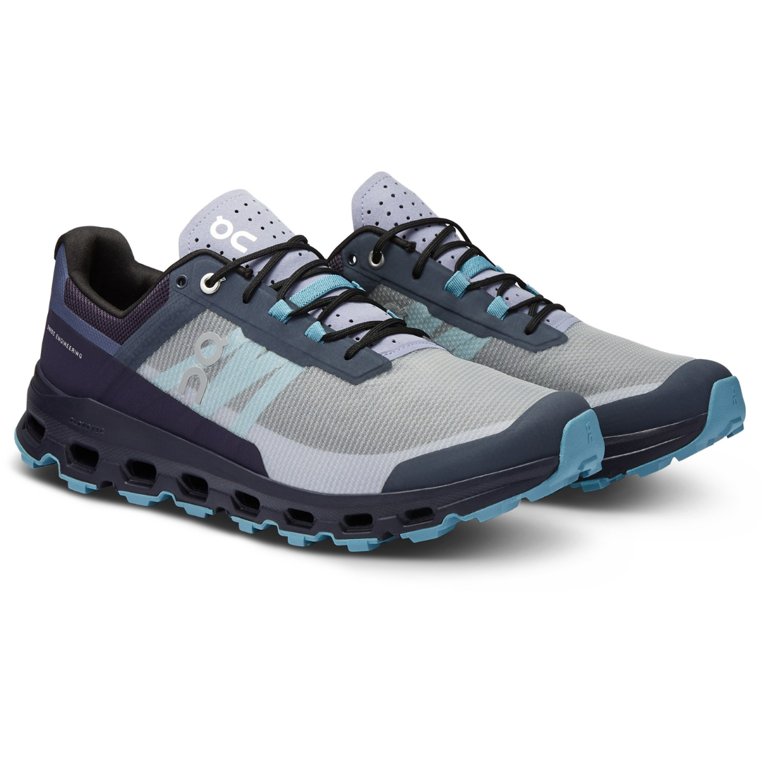 A pair of gray and navy trail running shoes with teal accents.