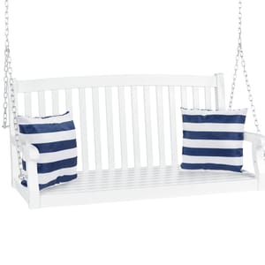 A white wooden porch swing with a slatted back and seat, suspended by metal chains, is adorned with two blue and white striped cushions.