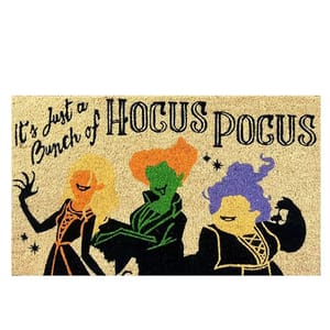 A doormat featuring stylized silhouettes of three witches with the text \“It's Just a Bunch of HOCUS POCUS,\“ referencing a popular Halloween theme.