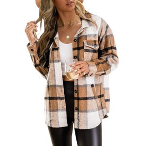 A woman is wearing a plaid shirt jacket over a white tank top, paired with black leggings, accessorized with layered necklaces.