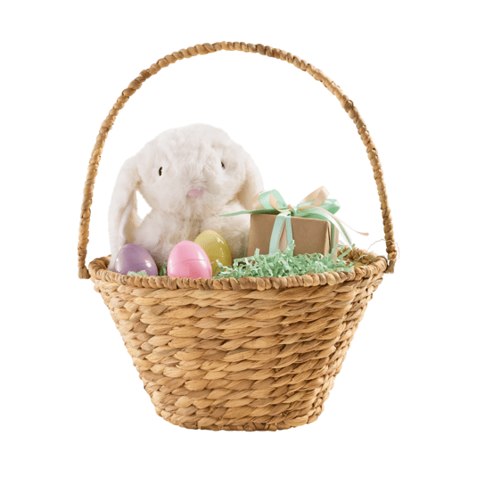 A woven basket containing a plush bunny, pastel-colored eggs, and a small wrapped gift with ribbons, set on shredded green paper.