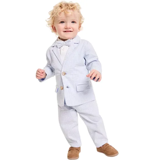 A toddler is wearing a light blue pinstripe suit with a matching bow tie, white shirt, and brown loafers.