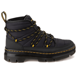 Dr. Martens Combs Padded Boots feature a high-top design with black quilted material, rugged black sole, and yellow-accented laces. The boots have distinctive yellow stitching along the sole and a heel loop for easy wear.