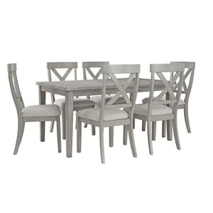 The 7-piece Signature Design by Ashley Dining Set features a rectangular gray table with a wood finish and six matching chairs with X-shaped backrests and upholstered seats.