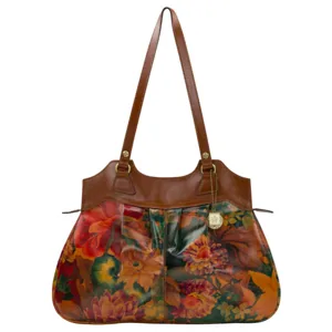 A floral-patterned handbag with brown leather handles and trim, featuring rich autumnal hues and a decorative pendant charm.