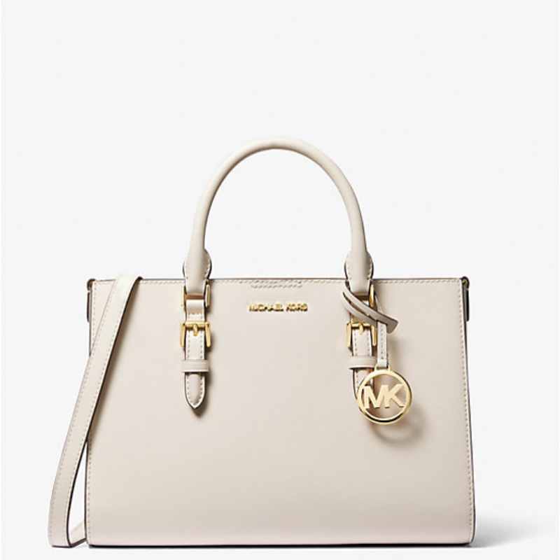 A pale beige handbag with gold-tone hardware and the Michael Kors logo.