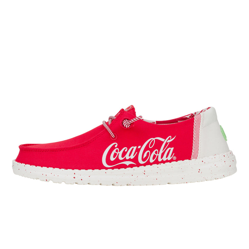 Red slip-on shoe with white Coca-Cola branding, featuring a speckled white sole and striped accents.