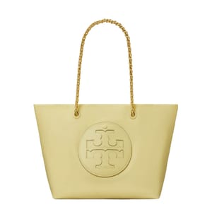 The Tory Burch Ella Chain Tote is a yellow tote bag featuring a large embossed logo on the front and two gold chain handles. It's a spacious and stylish accessory for carrying essentials.