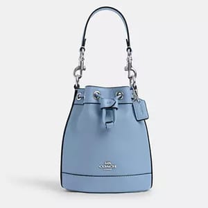 A blue leather Coach bucket bag with a silver chain strap and the brand logo on the front.