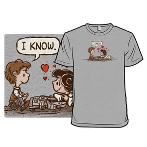 A gray T-shirt featuring a cartoon-style graphic of two characters, referencing a classic scene with the phrase \“I Know\“ in a speech bubble, surrounded by hearts.