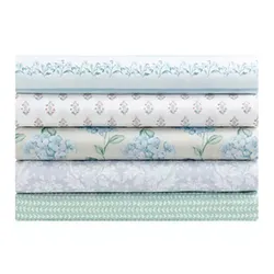 Stack of five folded fabrics with various floral and geometric patterns in blue, green, and white tones.