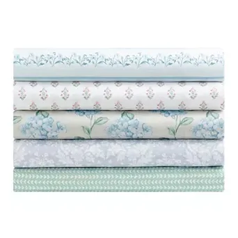 Stack of five folded fabrics with various floral and geometric patterns in blue, green, and white tones.