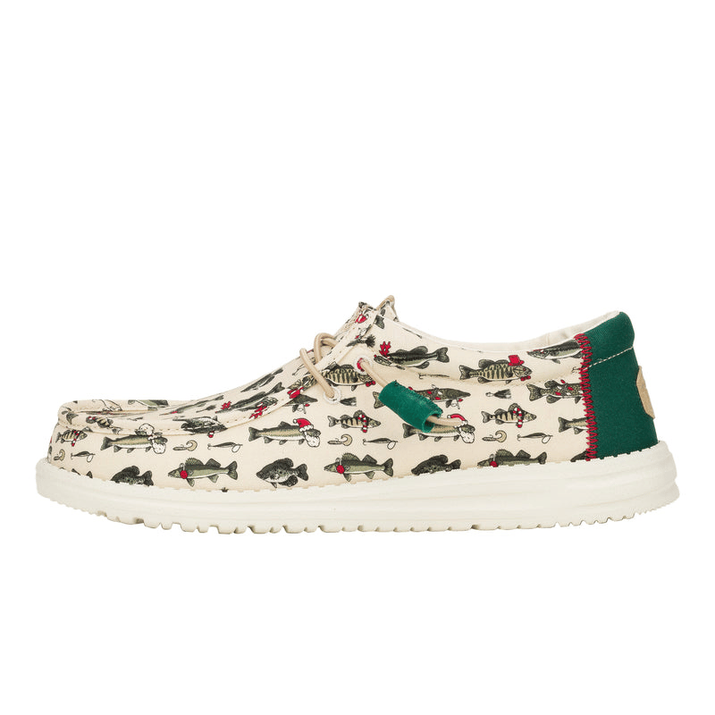 Cream-colored casual shoes with a playful fish pattern, featuring fish wearing Santa hats and hooks. They have tan laces, a green heel accent with red stitching, and a white sole.
