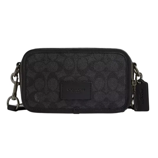 A compact black Coach crossbody bag featuring a signature logo pattern and detachable strap.