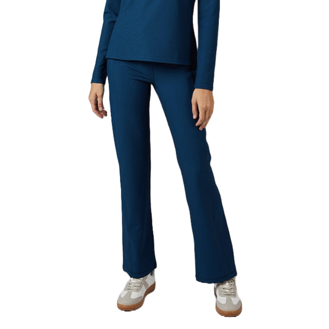 A woman is wearing a matching blue zip-up top and flared pants set with white sneakers.