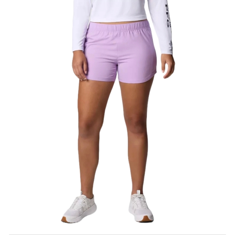 A person is modeling light purple athletic shorts paired with a white long-sleeve top and white sneakers.