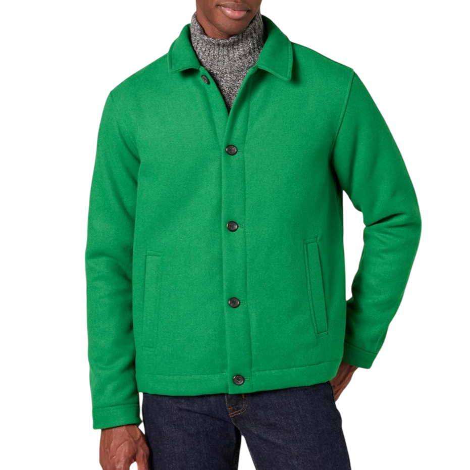 A man wears a green button-up wool jacket over a gray turtleneck sweater, paired with dark blue jeans.