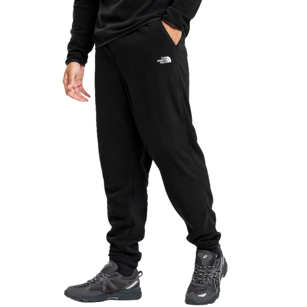 A person is wearing black fleece sweatpants with The North Face logo, paired with black hiking shoes.